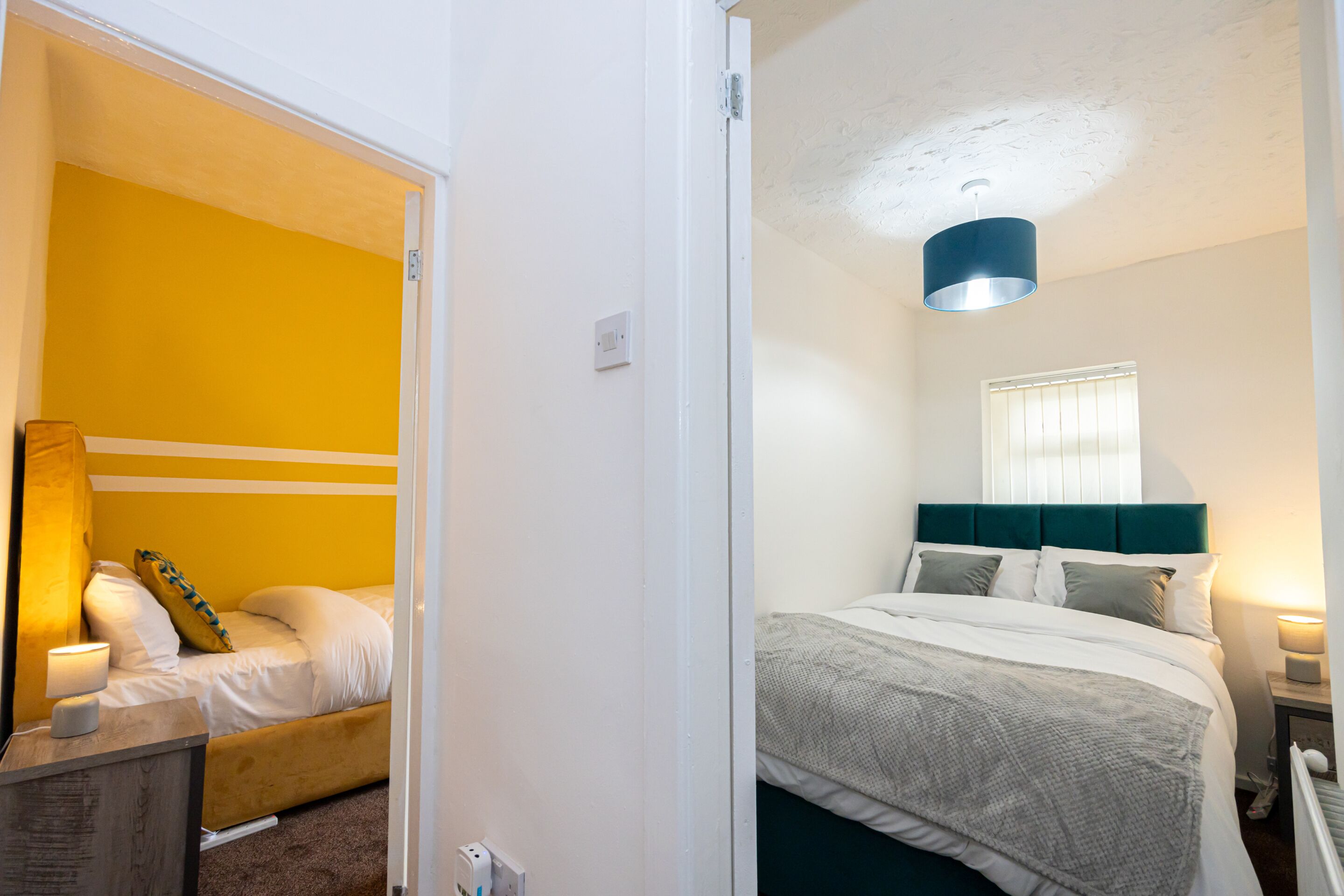 Ein Zimmer mit Bett, Nachttisch und Lampe.