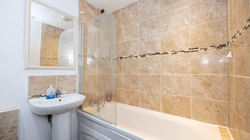 Ein Badezimmer mit einer Badewanne, einem Waschbecken und einer Dusche.