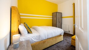 A bedroom with a bed, a nightstand, a lamp, a wardrobe, and a radiator. - Barnes Street Terrace (Accrington, Lancashire, United Kingdom)