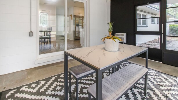 A modern interior with a marble table, a bench, and a potted plant. - Gainesville Getaway - Spacious, Fire Pit & Yard! (Gainesville)