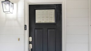 A black door with a white frame, a small window, and a doorbell. - Gainesville Getaway - Spacious, Fire Pit & Yard! (Gainesville)
