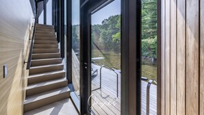 Escadaria que leva a um deck com vista para uma área arborizada.