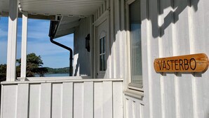 A white wooden building with a porch and a sign that reads "Vasterbo". - Holiday Home in Stenungsund (Stenungsund)