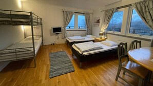 A dormitory room with bunk beds, a single bed, a TV, a table, and a chair. - Holiday Home in Stenungsund (Stenungsund)
