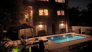A two-story house with a swimming pool, outdoor seating, and a staircase leading to the upper floor. - Fire Island Pines Oasis w/4 King Bdrms, Heated Pool, Hot Tub, Ocean & Bay Views (Sayville)