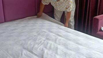 A bed with a white mattress and a purple headboard.