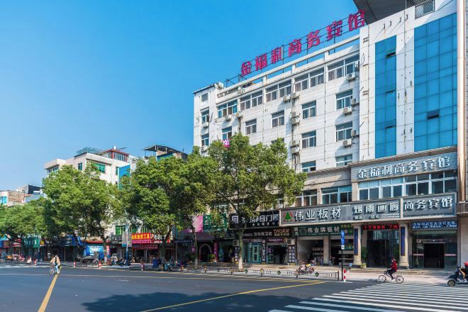 A multi-story hotel with a modern facade, located on a busy street with various shops and pedestrians.