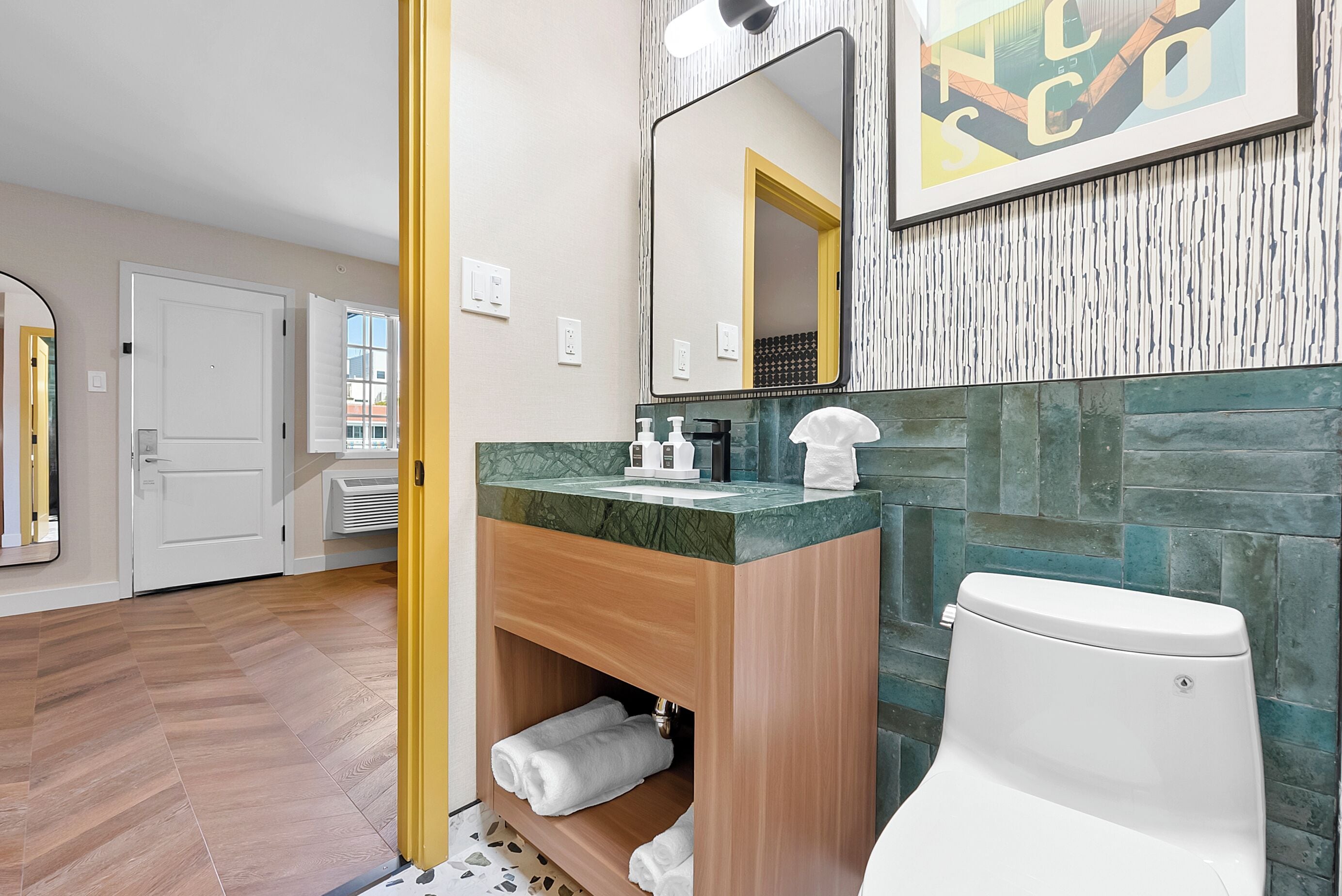A modern bathroom with a wooden vanity, a large mirror, and a toilet.