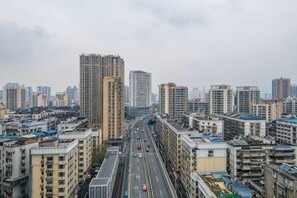 A cityscape with high-rise buildings, a multi-lane road, and a pedestrian walkway. - Yulan Hotel (Yichang CBD Shopping Center) (Yichang)