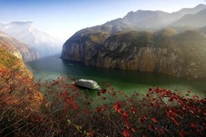 A boat on a calm lake surrounded by mountains. - Yulan Hotel (Yichang CBD Shopping Center) (Yichang)