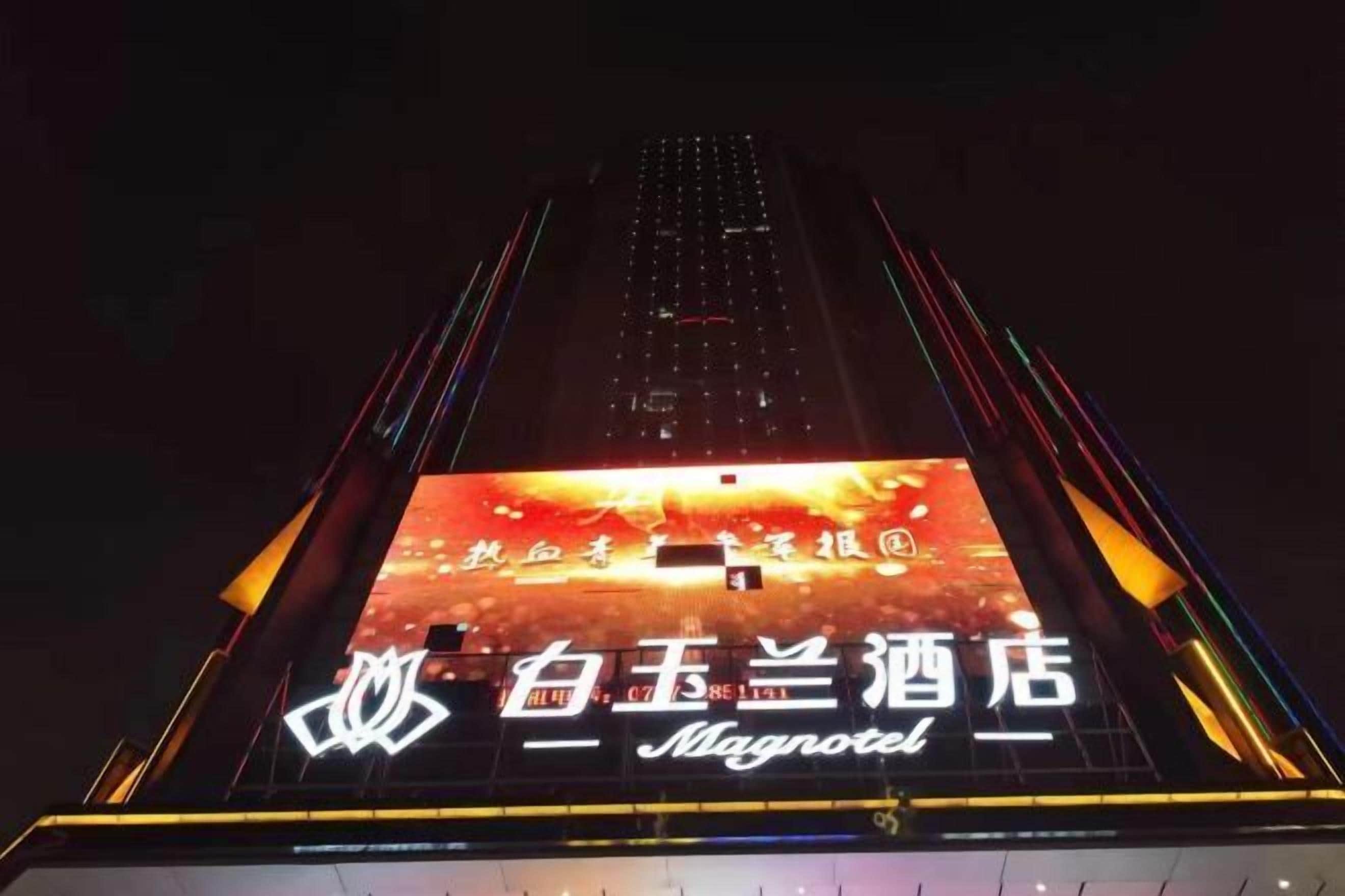 A hotel sign with a large illuminated display and a prominent logo.