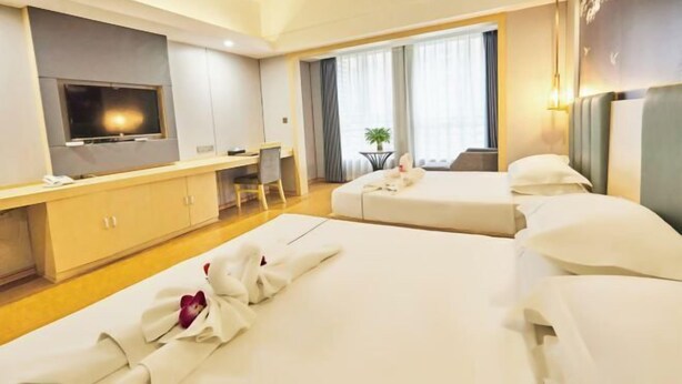 A hotel room with two beds, a desk, a television, and a window with curtains. - Magnotel Hotel (Yichang CBD Shopping Center) (Yichang)
