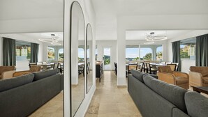 Eine geräumige, moderne Hotelhalle mit einer zentralen Gastronomie, großen Fenstern und zeitgemäßer Einrichtung.
