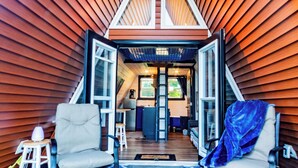 An interior view of a wooden cabin with a lofted sleeping area, a kitchen, and two chairs. - A FRAME ALPHA -WoW This Old Tree
 (Five Islands)