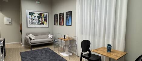 Una sala de estar moderna con un sofá, una mesa de centro y un comedor con sillas y una mesa.