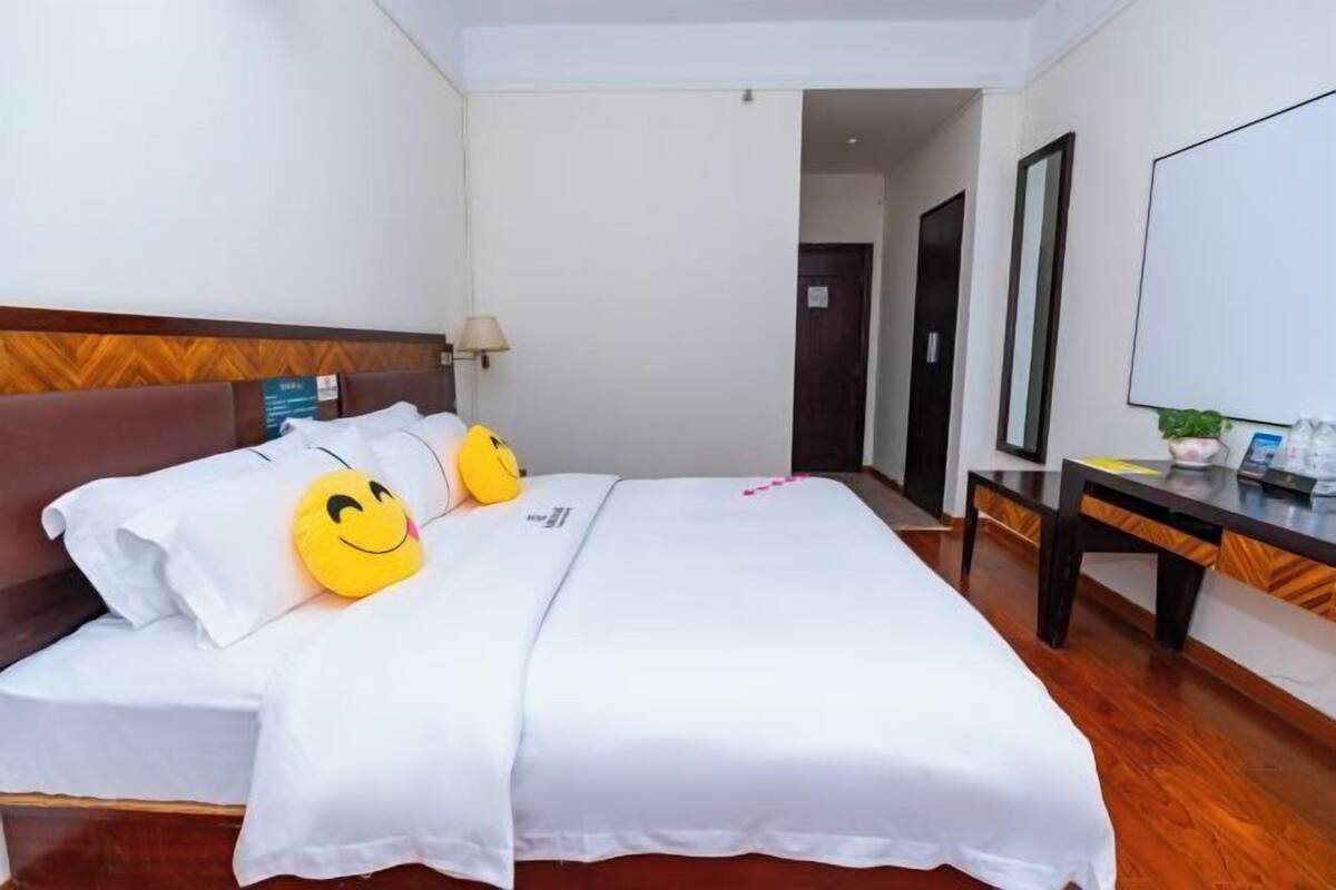 Ein Hotelzimmer mit Bett, Kissen, Schreibtisch und Stuhl.