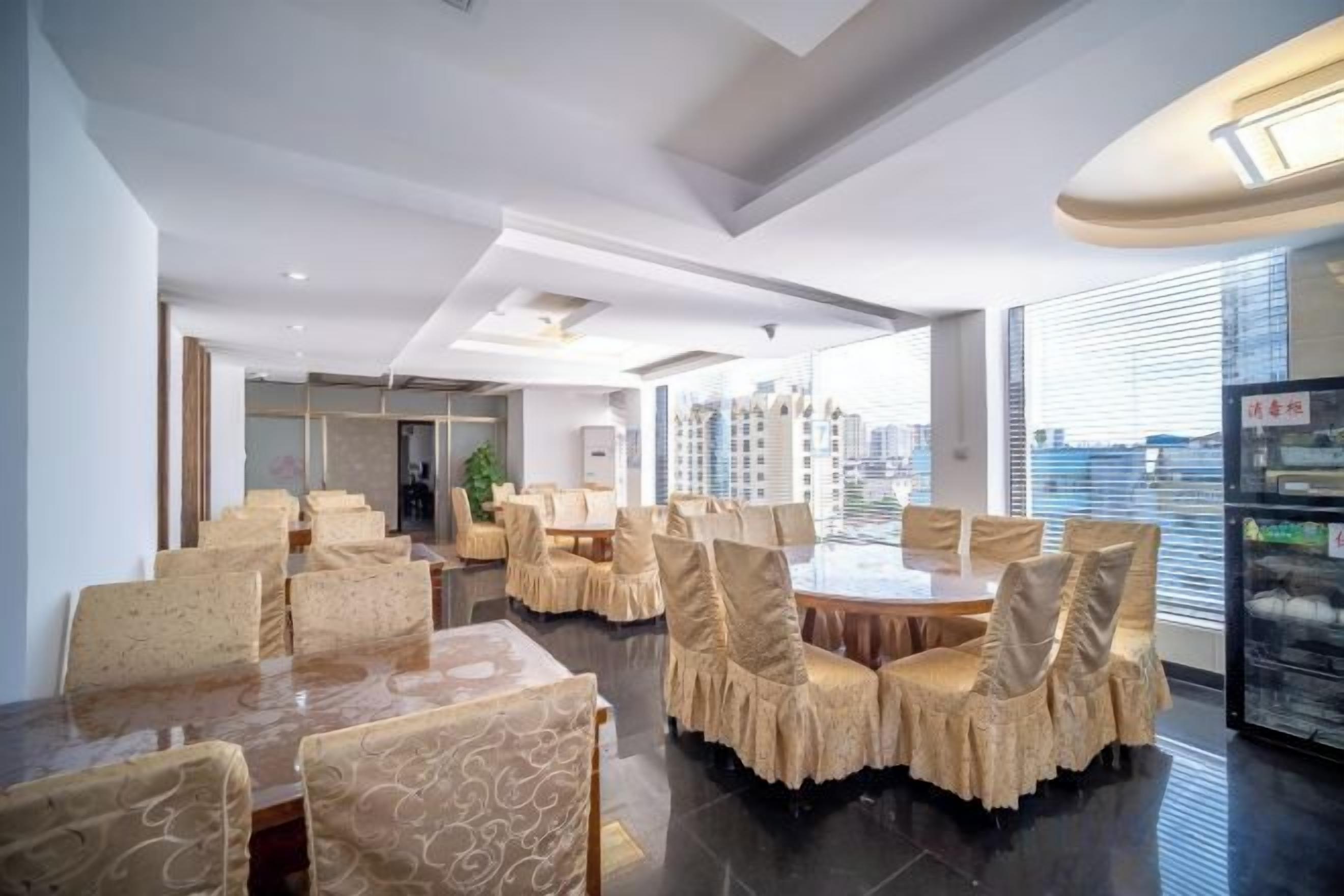 A modern dining area with round tables and chairs, large windows, and a city view.
