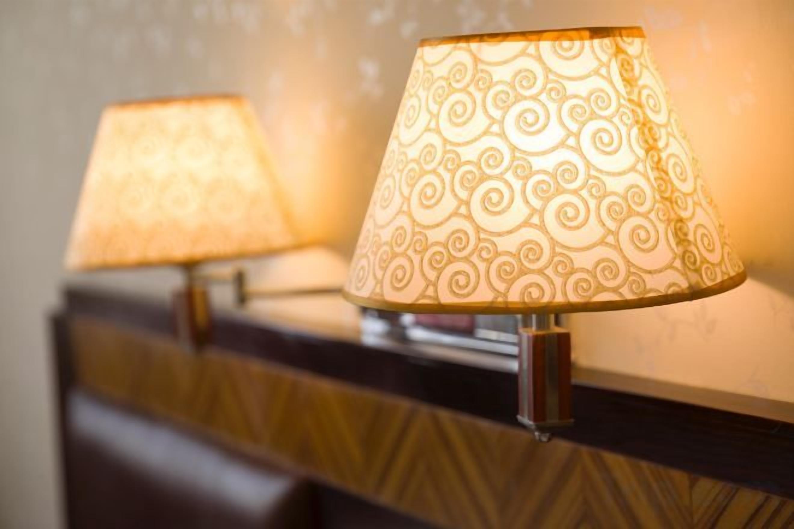 Twee lampen met versierde kap op een houten oppervlak.