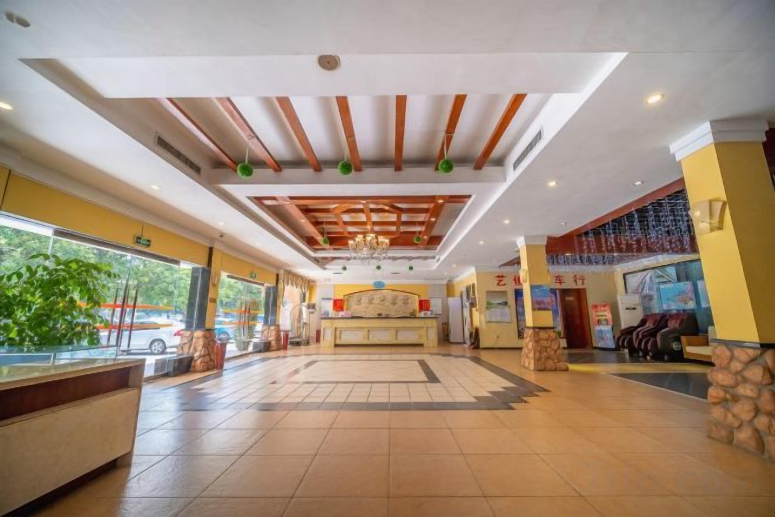 Eine Hotelhalle mit einer Rezeption, einem großzügigen Sitzbereich und Blick ins Freie.