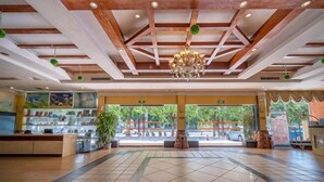Eine großzügige Lobby mit hoher Decke, einem Chandelier und Blick ins Freie.