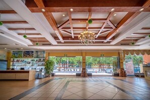 Un'ampia hall con soffitto alto, un lampadario e vista sull'esterno.