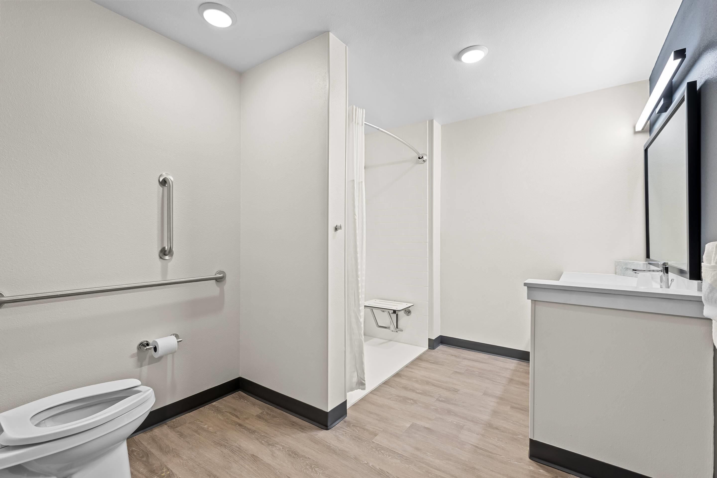 Une salle de bain moderne équipée de toilettes, d’une douche et d’un lavabo.