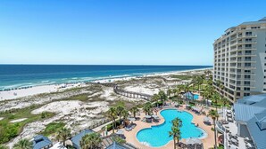 Un resort con una piscina grande, acceso a la playa y vista al océano.