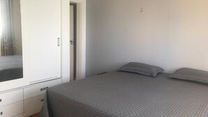 A bedroom with a bed, a wardrobe, and a door leading to another room. - Stunning view! Sea Front! (Mucuripe Fortaleza)