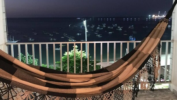 A hammock on a balcony overlooking a marina at night. - Stunning view! Sea Front! (Mucuripe Fortaleza)