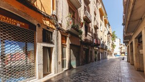 Una calle adoquinada con tiendas cerradas y edificios con balcones.