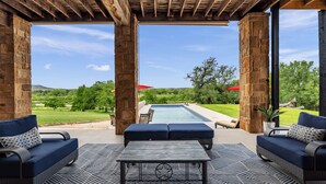 An outdoor patio with stone pillars, a pool, and seating areas. - Pool, Sandy Beach & Amazing Lake Sunsets, Sleeps 16, Family Retreat + Game Room (Kingsland)