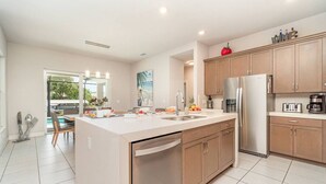 Una cocina moderna con una isla central, electrodomésticos de acero inoxidable y armarios de madera.