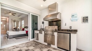 Una cocina moderna con electrodomésticos de acero inoxidable, una isla grande y un comedor.