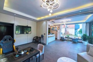 A modern hotel room with a dining area, a large window, and a view of the outside.