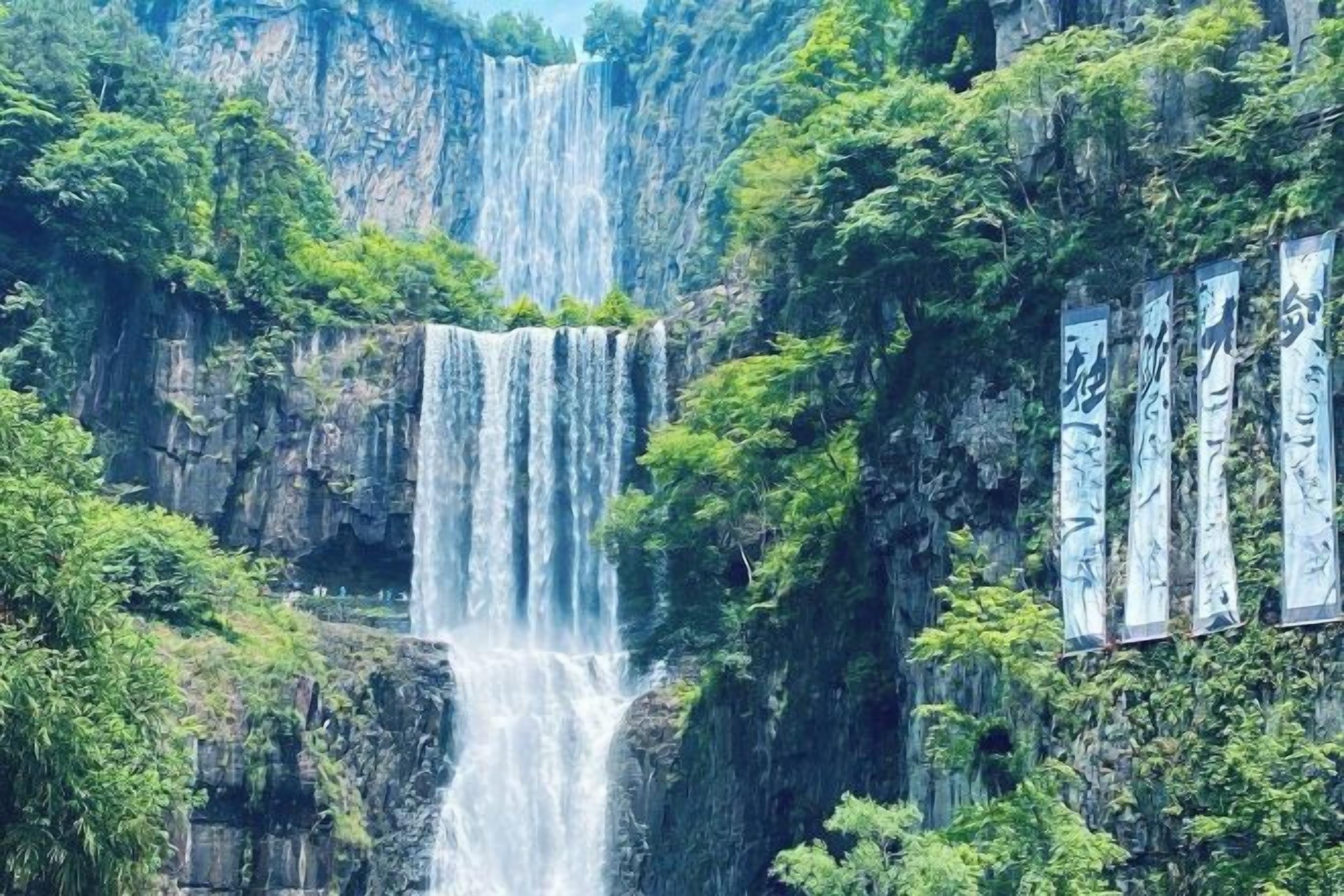 A waterfall cascading down a rocky cliff surrounded by lush greenery.