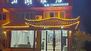 A traditional building with a signboard, a large glass entrance, and a well-lit interior.