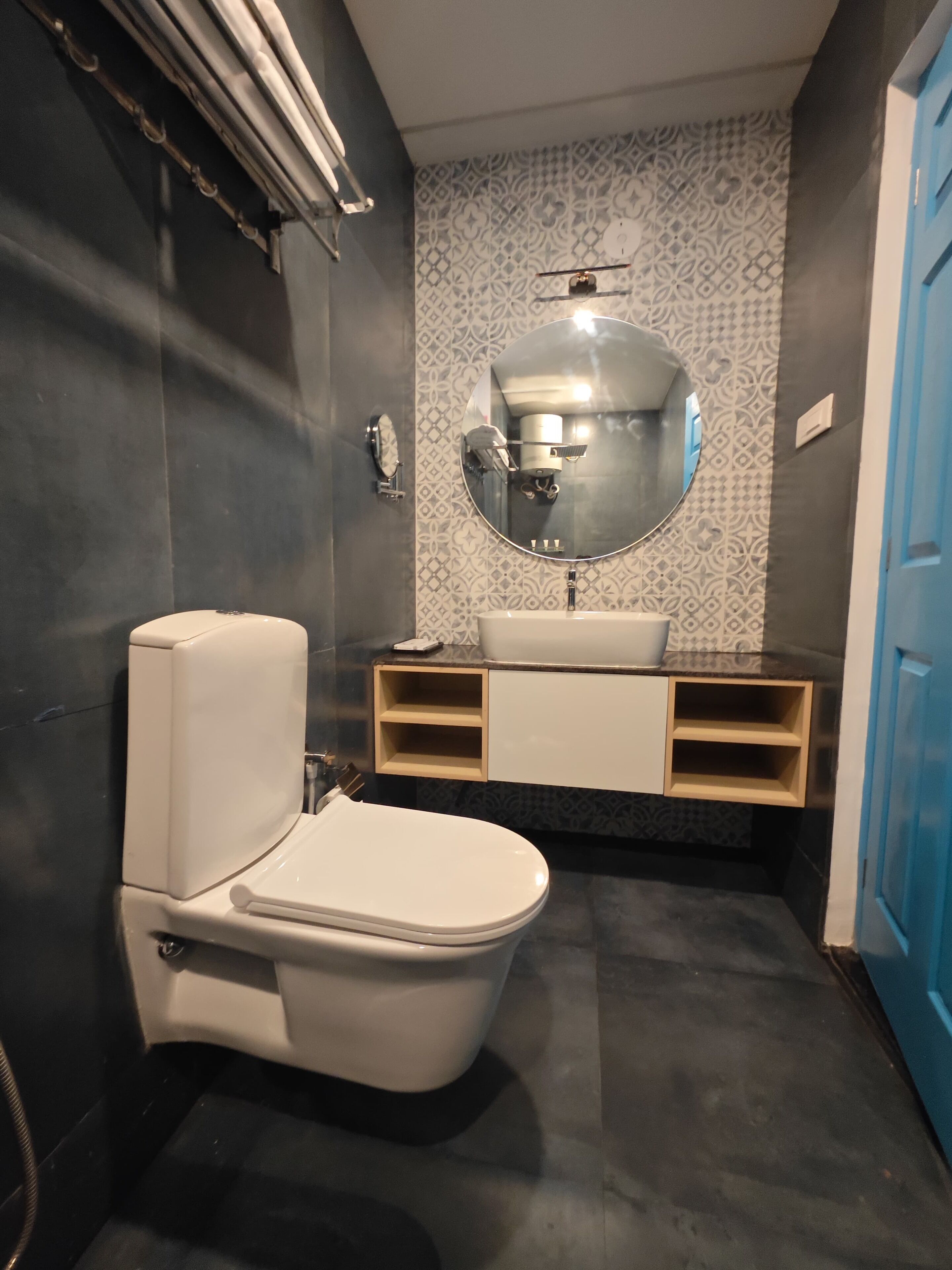 A bathroom with a toilet, sink, and mirror.