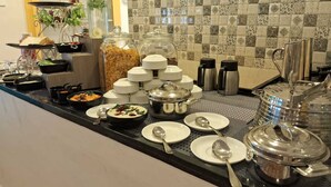 A buffet setup with various dishes, serving utensils, and condiments. - Ibex Resorts Coimbatore Kakarala (Coimbatore)