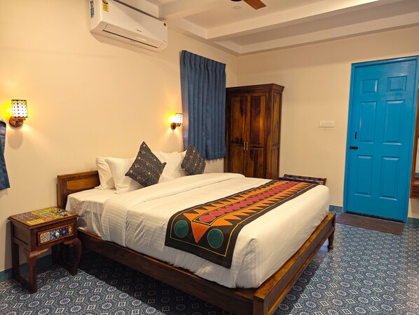 Un dormitorio con cama, mesita de noche, armario y puerta azul.