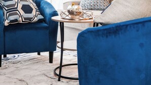 A room with two blue armchairs, a small round table with a vase and glasses, and a window with curtains. - Upscale 2 Queen Beds/2 Bath in Charlotte University Area (Charlotte)