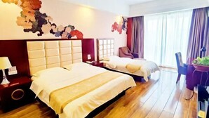 Habitación de hotel con dos camas, piso de madera, pared de acento roja y un amplio ventanal con cortinas.