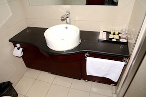 A bathroom with a white sink, dark countertop, and a mirror above it. - Dingyuan Hotel (Shizuishan)