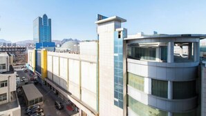 Un edificio moderno con fachada curva, ventanas amplias y una torre destacada.