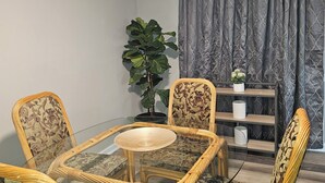 A dining area with a glass-top table surrounded by wicker chairs with patterned upholstery. - Family-Friendly 4BR Home in Elkton - AC, High-Speed WiFi & Relaxing Vibes (Elkton)