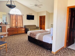 A bedroom with a bed, a desk, a chair, a television, and a wardrobe. - Dew Drop Inn Motel by OYO Miller SD (Miller)