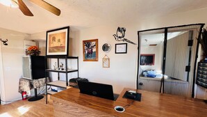 A room with a wooden desk, a laptop, a clock, and a framed picture on the wall. - Dew Drop Inn Motel by OYO Miller SD (Miller)
