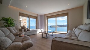 Un salon moderne avec un ensemble de canapés, une table basse et une vue sur la mer.
