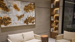 Un salon moderne comprenant un canapé, des fauteuils, une table basse et une bibliothèque.