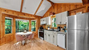 A wooden cabin with a kitchen featuring a refrigerator, stove, and cabinets. - Up Country, Creekside/Hot Tub (Dahlonega)