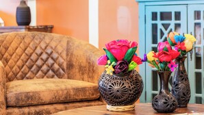 A room with a tufted sofa, two decorative vases with colorful flowers, a lamp, and a teal cabinet. - Views, King bed, EV charger, 5 min to Downtown (Paso Robles)